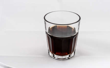Dark brown drink in a glass on white background.の写真素材