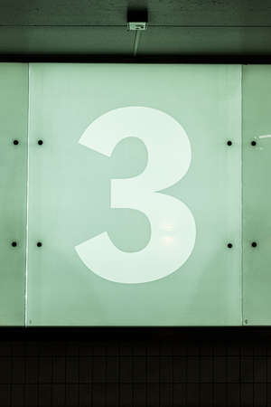 The number three, 3, on a glass wall.