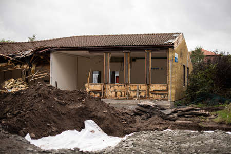 An old school being demolished. Windows and walls are gone and the roof is coming down.