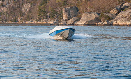Blue and white speed boat cuising on a fjord.の写真素材