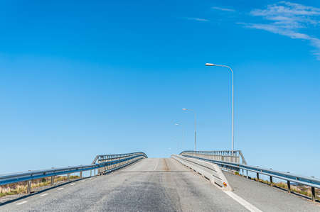 Looking up an empty, grey bridge.