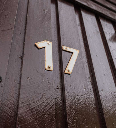 The number seventeen, 17, in white metal letters on a brown house.の写真素材