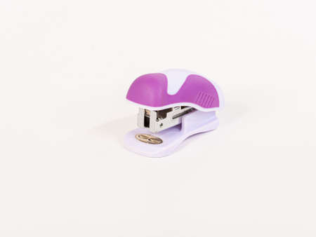 Small, pink stapler with a rounded design on white background.