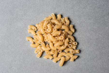 A pile of macaronis on grey background.