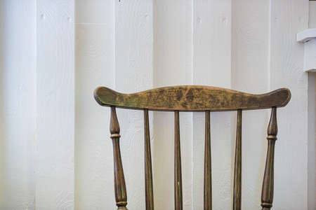 Wooden chair by a white wall.の写真素材