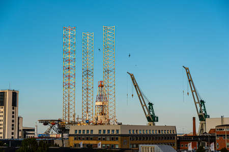 Jack up rig and cranes at a wharf.