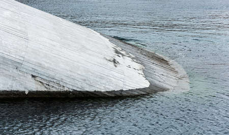 Concrete structure going into the water at a sloping angle.