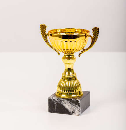 Gold trophy with marble base on light grey background.の写真素材