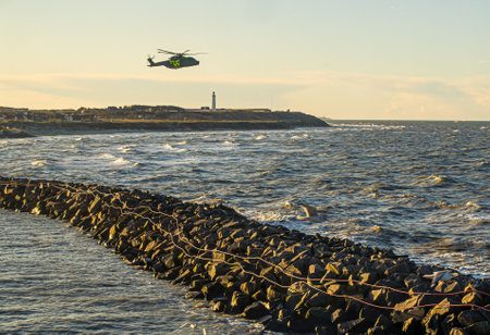 Hirtshals , Denmark - December 28 2009: AgustaWestland AW101, EH101 Merlin, Danish SAR helicopter in action outside Hirtshals harbour.のeditorial素材