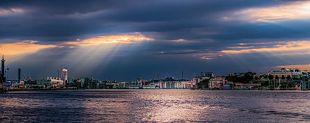 Gothenburg , Sweden - September 12 2013: Streams of sunlight through the clouds over the harbour of Gotenburg.のeditorial素材