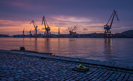 Gothenburg , Sweden - February 27 2015: Cranes of and old wharf in a beautiful sunset.のeditorial素材
