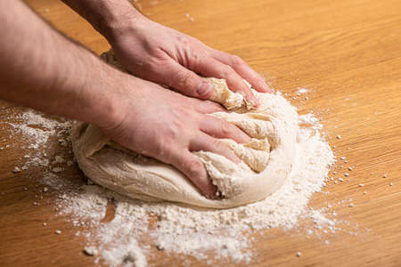 Kneading dough on a wooden table.の写真素材