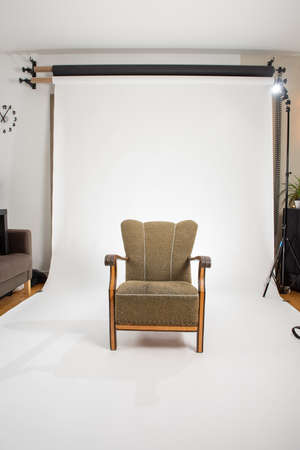 An old and empty, green chair in a photo studio.の写真素材
