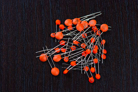 A pile of orange ceramic capacitors on black background.