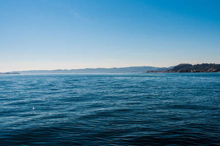 View over small waves at sea with land in the horizon..の写真素材
