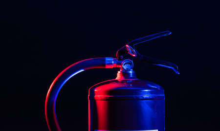 Fire extinguisher lit by blue and red light..の写真素材