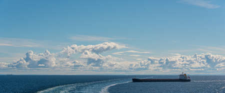 Tank ship passing the wake of a ferry on a summer day..