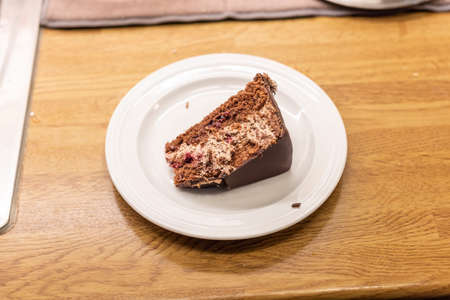 Chocolate cake on its side on a white plate..の写真素材