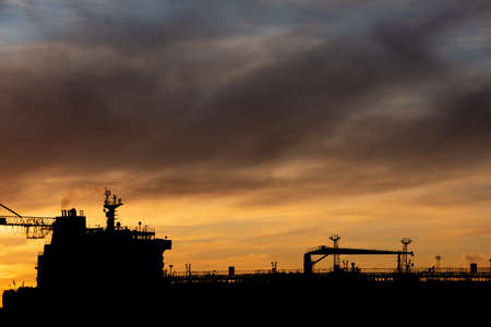 Silhouette of an oil tanker at sunset.の写真素材