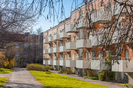 Facade of an orange apartment building with white balconies.の写真素材