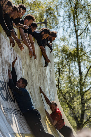 Gothenburg, Sweden - April 26 2014: Participants of the Tough Viking obstacle race in Slottsskogen trying to climb a wall.のeditorial素材