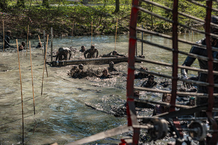 Gothenburg, Sweden - April 26 2014: Participants of the Tough Viking obstacle race in Slottsskogen swimming through murky waters.のeditorial素材