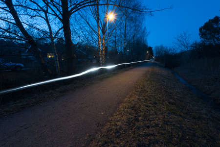 Bike road at night. Ling exposure photo of a white bile lamp..の写真素材
