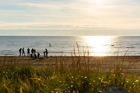 Small group of people on a beach at sunsetの写真素材