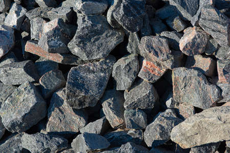 A pile of grey and some pink rocks