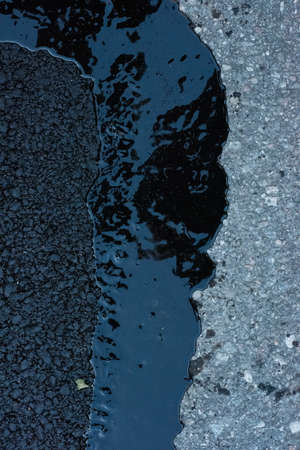 Newly repaired asphalt on a small roadの写真素材