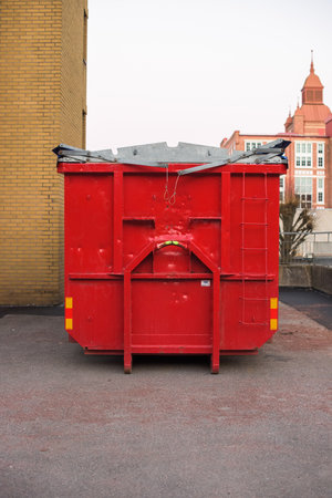 Red trash container with a sad face on it..