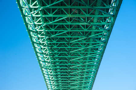 Green stiffening truss of a suspension bridge viewed from underneath.の写真素材