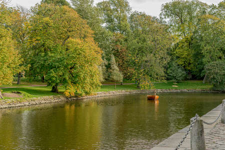 Person standing in a wooden boat fishing in the canals in the city center.の写真素材