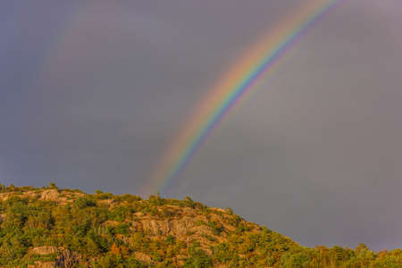 Rainbow above a mountain on a warm summer day.の写真素材