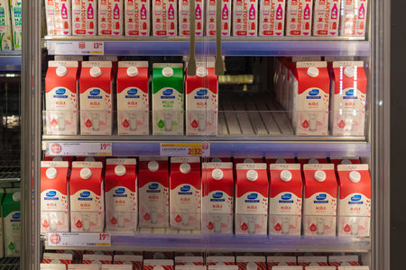 Gothenburg, Sweden - May 22 2021: A single green milk carton in between severan red milk cartons. Triggering som peoples OCDのeditorial素材