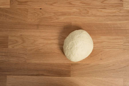 Wheat dough rising on a wooden table.の写真素材