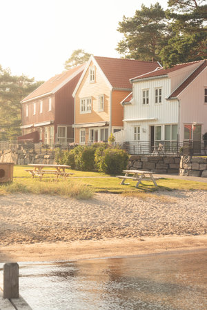 Lindesnes, Norway - August 04 2021: Traditional summer houses by a small beach at sunsetのeditorial素材