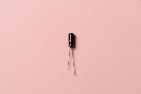 A black small capacitor on pink backgroundの写真素材