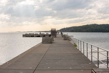 Long concrete pier with wooden benches.の写真素材