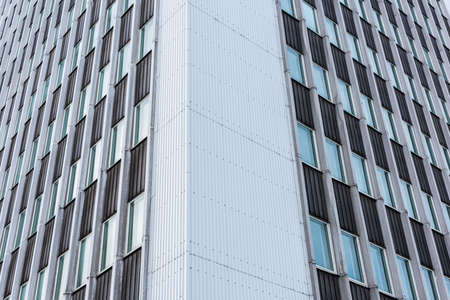 Looking up tall glass and concrete office high-rise building
