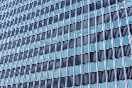 Looking up tall glass and concrete office high-rise buildingの写真素材