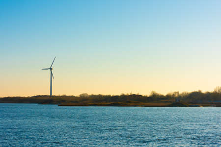 A lonely wind turbine by the sea.の写真素材