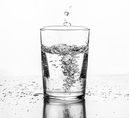 Water being poured into a glass. White background..の写真素材