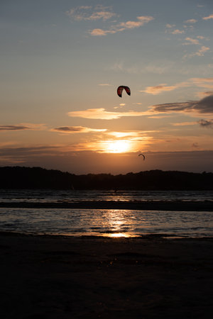 Gothenburg, Sweden - October 10 2021: Kiteboarders kitesurfing in the sunset at a beachのeditorial素材
