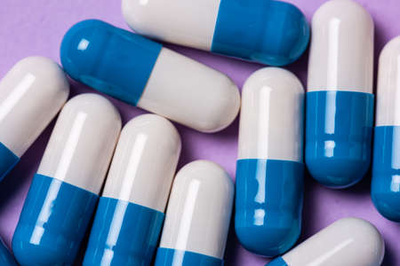 White and blue medicine pills on a table