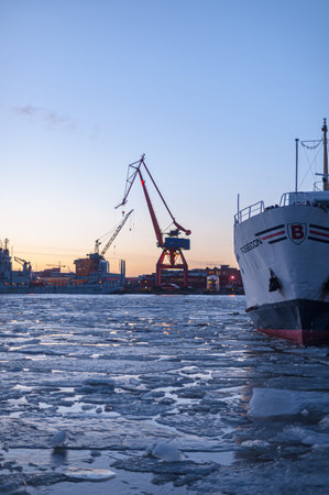 Gothenburg, Sweden - February 08 2011: Icy river basin with colorful sunset and crane in silhouette