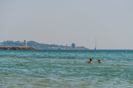 Helsingborg, Sweden - July 17 2021: People swimming at a beach by a lighthouseのeditorial素材