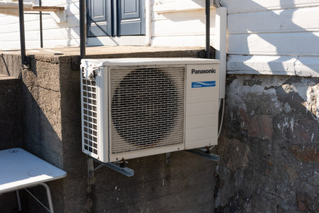 Lindesnes, Norway - April 15 2022: Panasonic inverter heat pump on an old wooden houseのeditorial素材