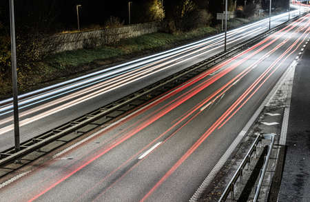 Long exposure night photo of busy highway traffic.