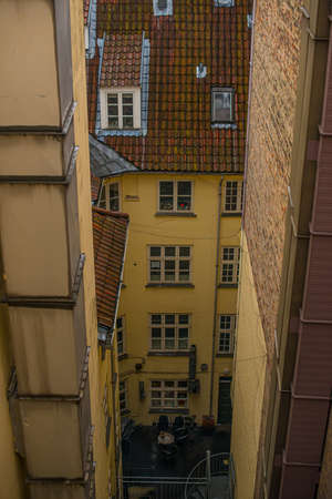 Vertical view of the backyard of an old yellow building.